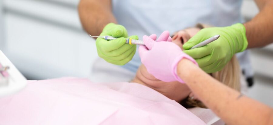 handen met handschoen van tandarts en assistent